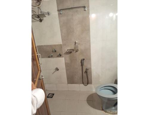 uma casa de banho com um chuveiro e um WC. em Hotel Kamal Palace,Panjim em Panaji