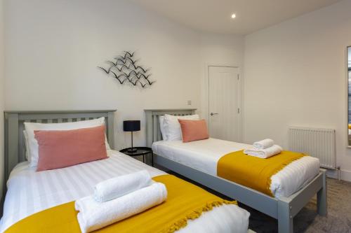 dos camas sentadas una al lado de la otra en un dormitorio en Heyshott Manor - Luxury 5 bedroom house in Portsmouth en Portsmouth