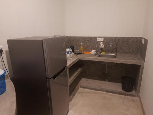 a small kitchen with a sink and a refrigerator at Hotel Paradiso, in Unawatuna