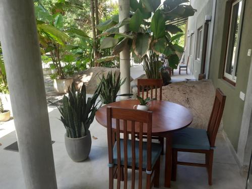 a wooden table and chairs in a room with plants at Hotel Paradiso, in Unawatuna