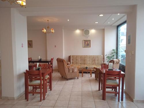 una sala de espera con mesas y sillas y un sofá en Thiamis Guesthouse en Doliana