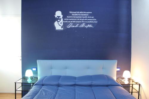 1 dormitorio con una pared azul y 1 cama en Rooms Of Love, en Pavia