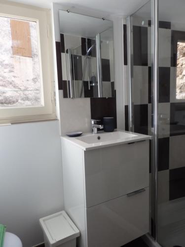 y baño con lavabo blanco y ducha. en Le Merlanson chambres d'hôtes, en Bez-et-Esparon