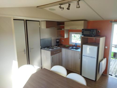 Boofzheimにあるmobil home 6 personnes, proche d'Europa Park et Rulanticaの小さなキッチン(冷蔵庫、テーブル付)