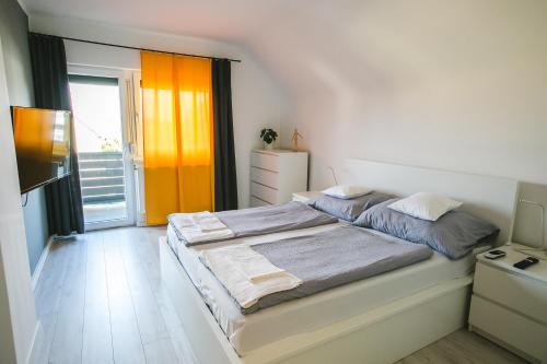 een slaapkamer met een groot bed en een raam bij Dream holiday at Balaton lake in Balatonlelle