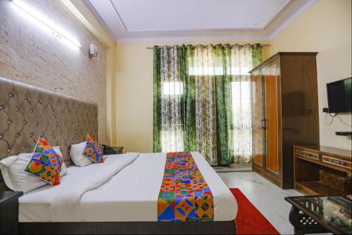 a bedroom with a large bed and a television at FabHotel HM Palace in Noida