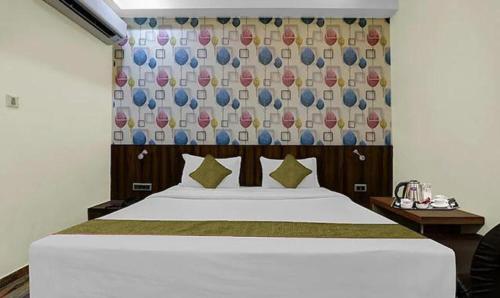 um quarto com uma cama branca e uma cortina em FabHotel Sam Inn em Lucknow