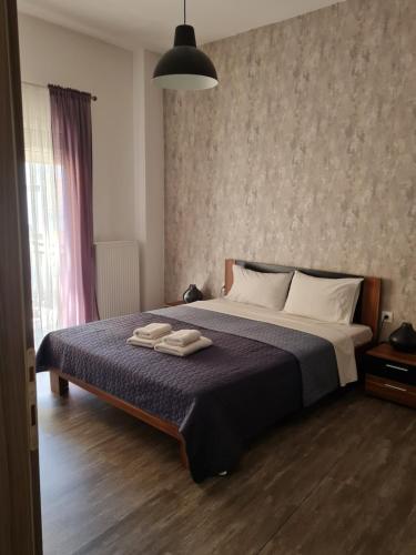 een slaapkamer met een bed met twee handdoeken erop bij Trikala Easy Living B1 kai B2 in Tríkala