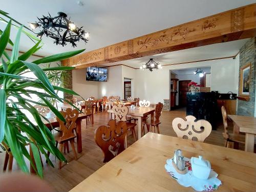a dining room with wooden tables and chairs at Chochołowskie Zacisze przy Termach - Apartamenty i Pokoje in Chochołów
