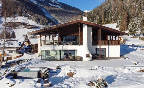 a house in the snow on a mountain at Chalet Villa Carolina in Selva di Val Gardena