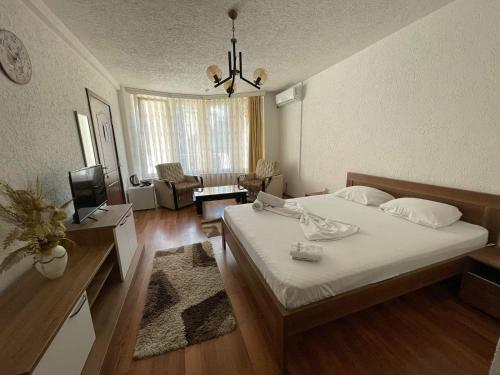a bedroom with a bed and a living room at Deni house in Prizren