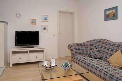 - un salon avec un canapé et une télévision dans l'établissement Haus Weisse Möwe Weisse Möwe 3, à Cuxhaven