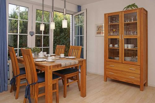 une salle à manger avec une table, des chaises et une armoire dans l'établissement Haus Weisse Möwe Weisse Möwe 3, à Cuxhaven