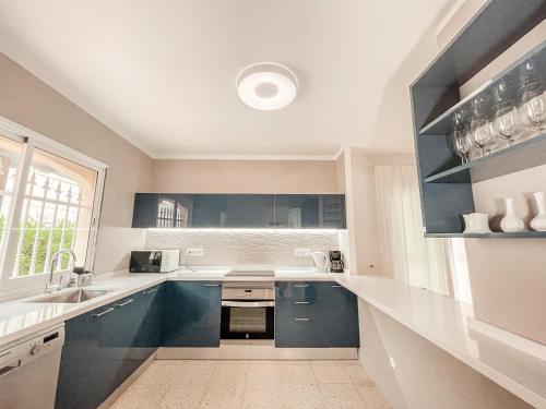 a kitchen with blue cabinets and a sink at Villa Julia in Callao Salvaje in Callao Salvaje