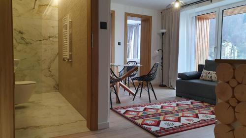 a living room with a couch and a table at Apartamenty Nowa Osada - by VillaOlimpijska2 in Wisła
