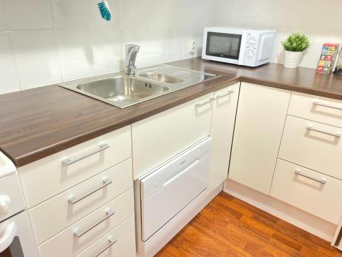 uma cozinha com um lavatório e um micro-ondas em Itäkadun Studio Apartment em Lahti