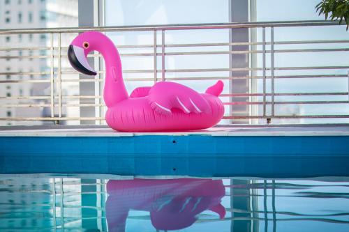 ein rosa Flamingo-Spielzeug, das am Rande eines Pools sitzt in der Unterkunft Moonlight Nha Trang Hotel in Nha Trang