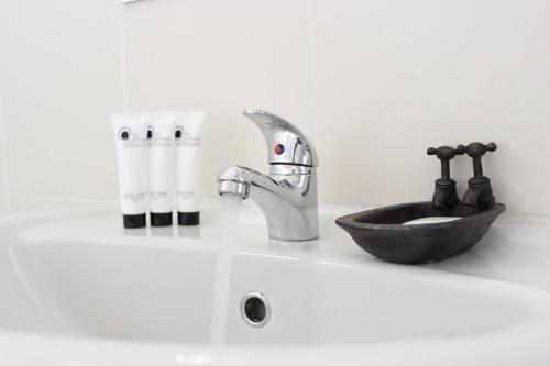 a bathroom counter with a sink and a sink at Blue Crane Guesthouse in Maseru