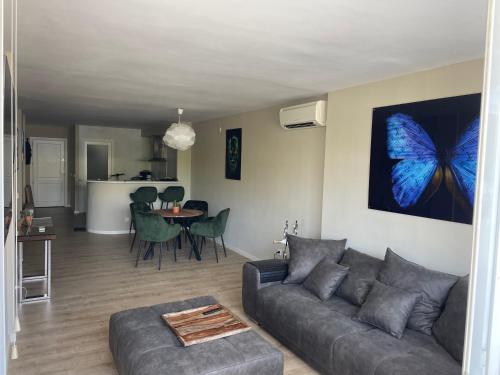 a living room with a couch and a butterfly painting on the wall at Ferienwohnung im Herzen von Cala Ratjada in Cala Ratjada