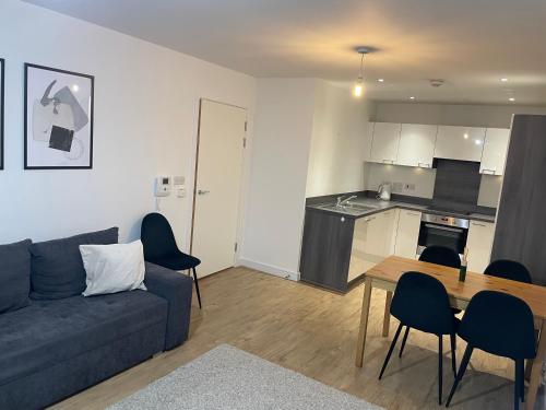 a living room with a couch and a table and a kitchen at Great 1Bed 10 mins from East Croydon with Free WiFi in Croydon