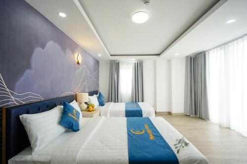 1 Schlafzimmer mit 2 Betten in Blau und Weiß in der Unterkunft Moonlight Nha Trang Hotel in Nha Trang