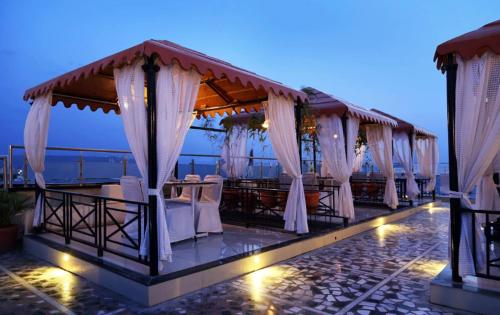 a restaurant with white curtains and tables and chairs at Hotel Atithi, Aurangabad in Aurangabad