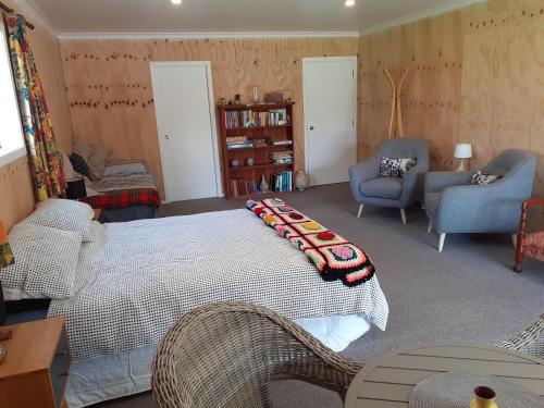a bedroom with a bed with a blanket on it at Pin Oaks in Whanganui