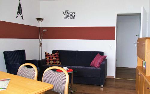 a living room with a blue couch and two chairs at Haus Seehütte Seehütte Haus 2 Wohnung 103 in Cuxhaven