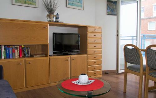 a living room with a tv and a cat on a table at Haus Seehütte Seehütte Haus 2 Wohnung 103 in Cuxhaven