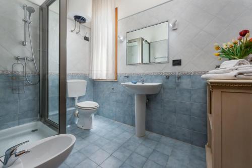 a bathroom with a sink toilet and a mirror at Coral sea B2 in San Vito lo Capo