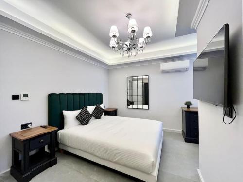 a bedroom with a white bed and a chandelier at Beautiful 4-Bedroom Townhouse in Sliema in Sliema