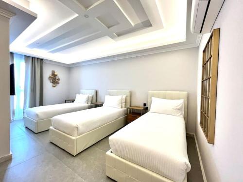 two beds and a couch in a room at Beautiful 4-Bedroom Townhouse in Sliema in Sliema