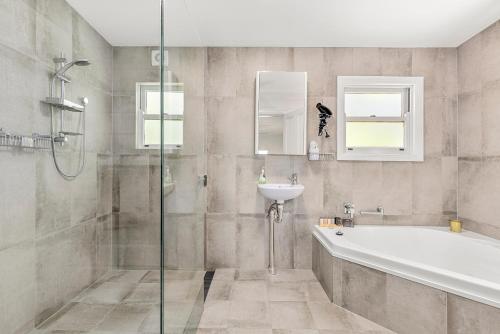 un baño con bañera y lavabo en 4 Bedroom Farm Cottage on the Bellinger River, en Bellingen