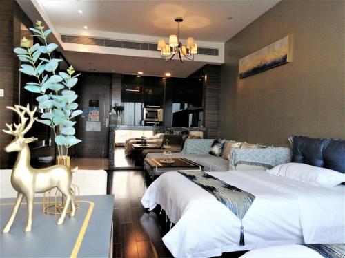 a bedroom with two beds and a living room at Yicheng Pazhou Poly World Trade Centre Apartment in Guangzhou