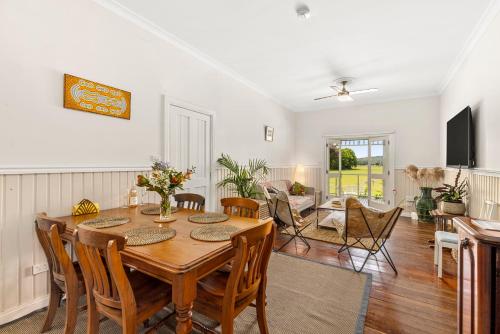 a dining room with a table and chairs at 4 Bedroom Farm Cottage on the Bellinger River in Bellingen