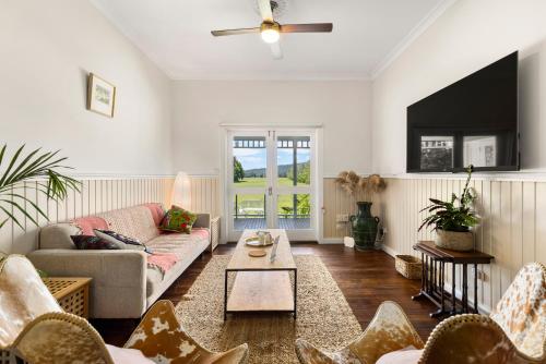 a living room with a couch and a table at 4 Bedroom Farm Cottage on the Bellinger River in Bellingen