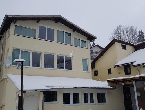 a house with snow on the front of it at Casa Oriana in Predeal