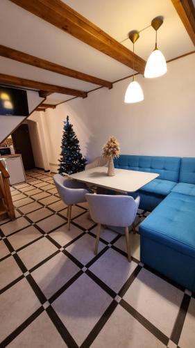 een woonkamer met een blauwe bank en een tafel en een kerstboom bij 12 Місяців-Травень, басейн з підігрівом in Slavske