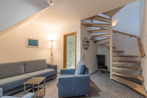 a living room with a couch and a spiral staircase at Haus Relax Appartements Duhnen Haus Relax Appartements Duhnen - Wohnung 2 in Cuxhaven