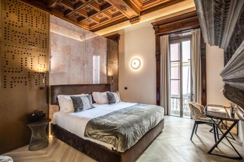 a bedroom with a king sized bed and a desk at Martius Private Suites Hotel in Rome