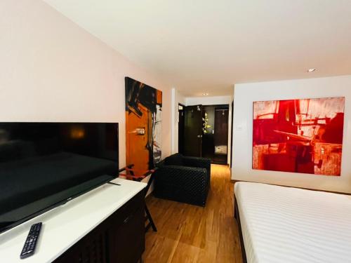 a bedroom with two beds and a flat screen tv at Baipho Lifestyle in Patong Beach