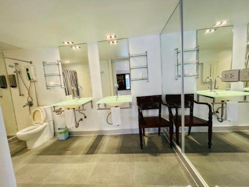 a bathroom with sinks and a toilet and mirrors at Baipho Lifestyle in Patong Beach