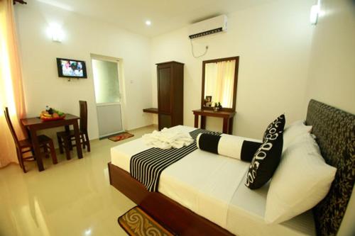 a hotel room with a bed and a television at Hotel Sanri Villa Katunayake in Minuwangoda