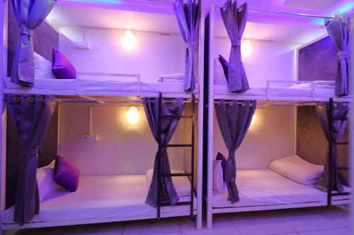 a group of bunk beds in a room with purple lighting at Perfectstayz Value Forest Valley Near Waterfall in Rishīkesh