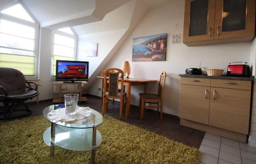 uma sala de estar com uma mesa e uma cozinha em Haus Elbe 1 Haus Elbe 1 - Wohnung 38 em Cuxhaven