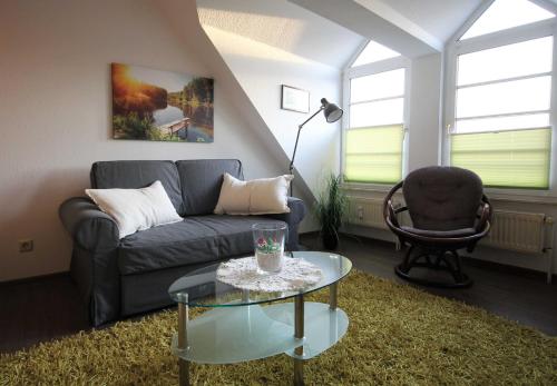 uma sala de estar com um sofá, uma mesa e uma cadeira em Haus Elbe 1 Haus Elbe 1 - Wohnung 38 em Cuxhaven