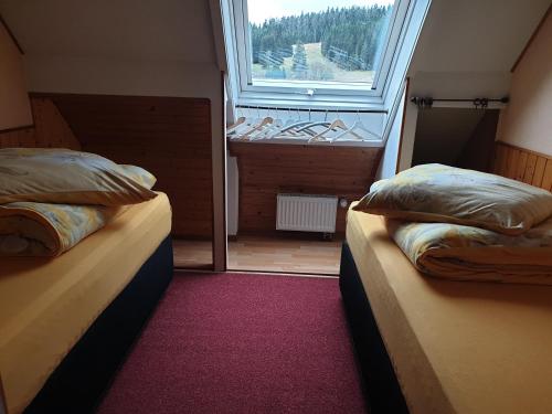 two beds in a small room with a window at Haus Gretel in Feldberg