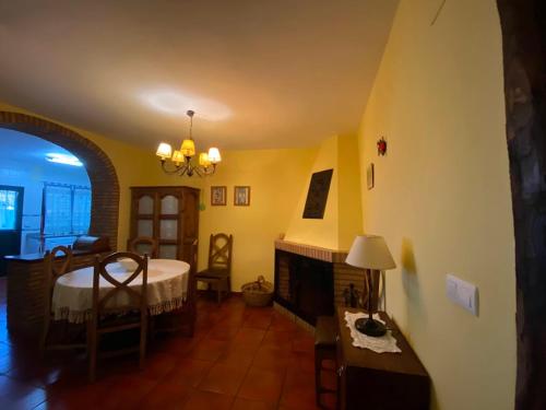 a living room with a table and a fireplace at Espaciosa y Elegante Casa Rural en Los Marines in Los Marines