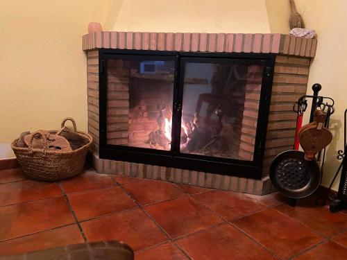 a brick fireplace with a fire in it at Espaciosa y Elegante Casa Rural en Los Marines in Los Marines