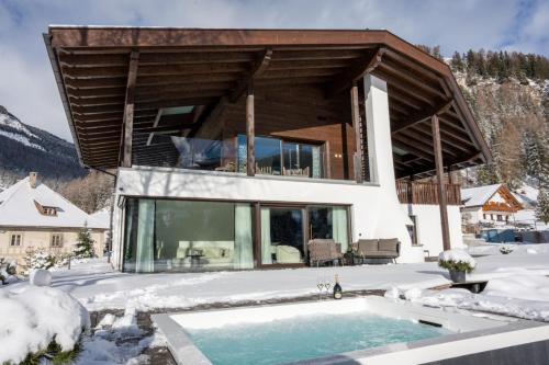 a house in the snow with a swimming pool at Villa Carolina in Selva di Val Gardena